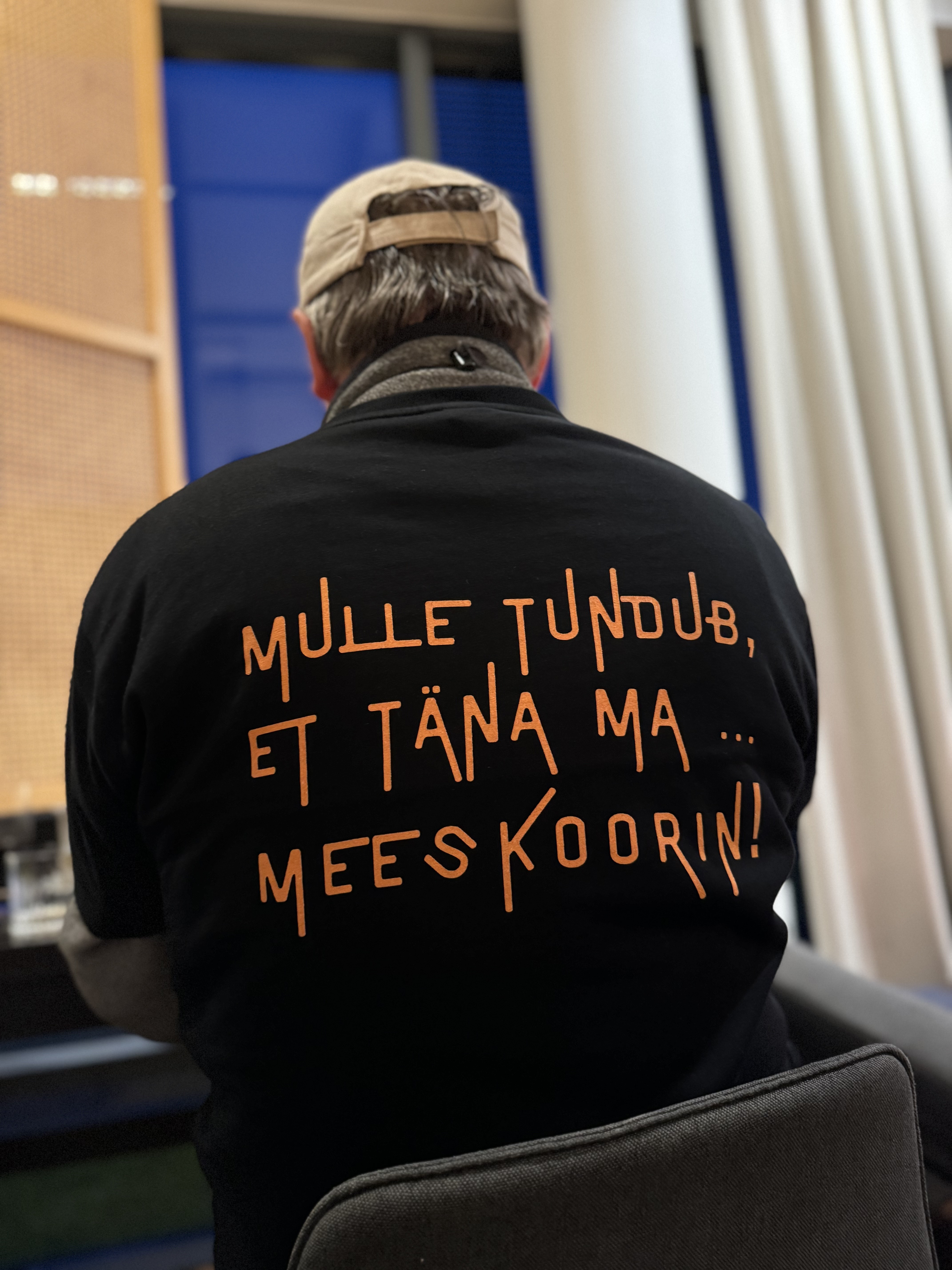 Lõbusa tekstiga pluus laulupeolise seljas Oru hotelli fuajees. 